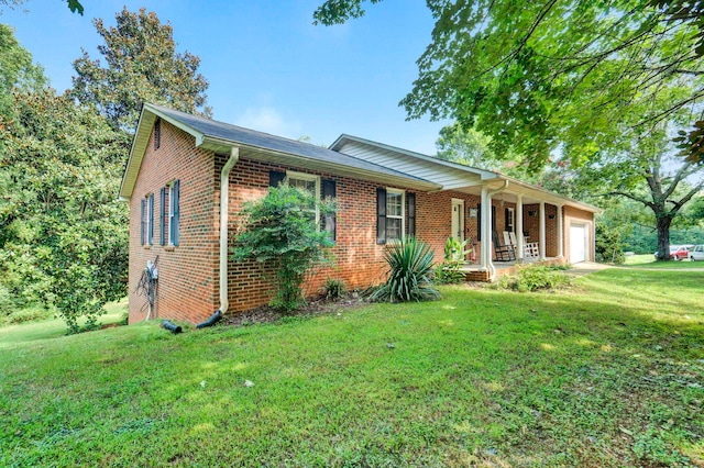 ranch-style home featuring a front lawn, a garage, and covered porch