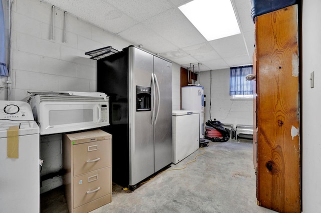 basement with a paneled ceiling, stainless steel fridge with ice dispenser, washer / dryer, and water heater