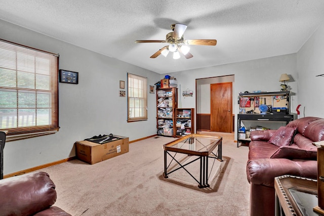 living room with ceiling fan, a textured ceiling, and carpet floors