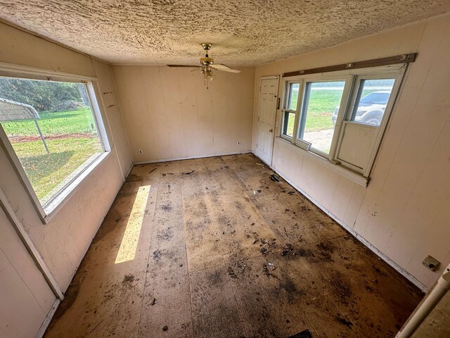 empty room featuring ceiling fan and a textured ceiling