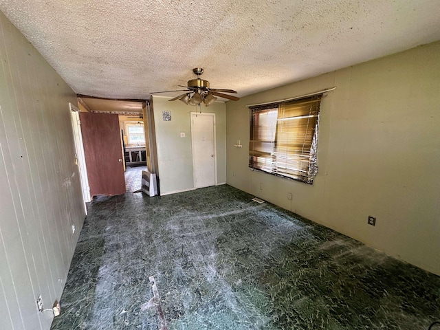 unfurnished bedroom featuring a textured ceiling and a ceiling fan