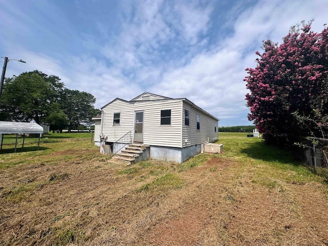 view of front of house with entry steps and a front lawn