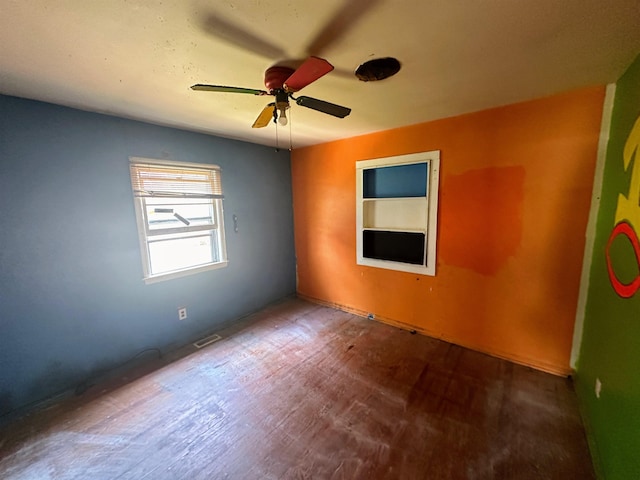 unfurnished room featuring ceiling fan, visible vents, and wood finished floors