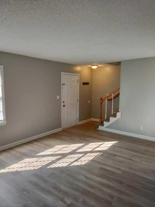 empty room featuring hardwood / wood-style flooring and a textured ceiling