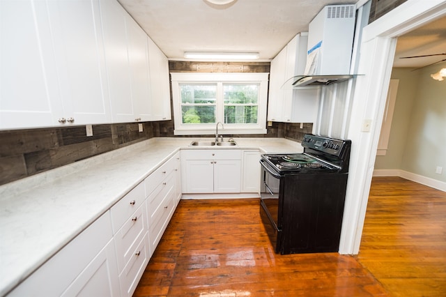 kitchen with custom range hood, white cabinetry, black range with electric cooktop, and sink