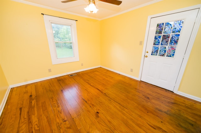 empty room with hardwood / wood-style flooring, ornamental molding, and ceiling fan