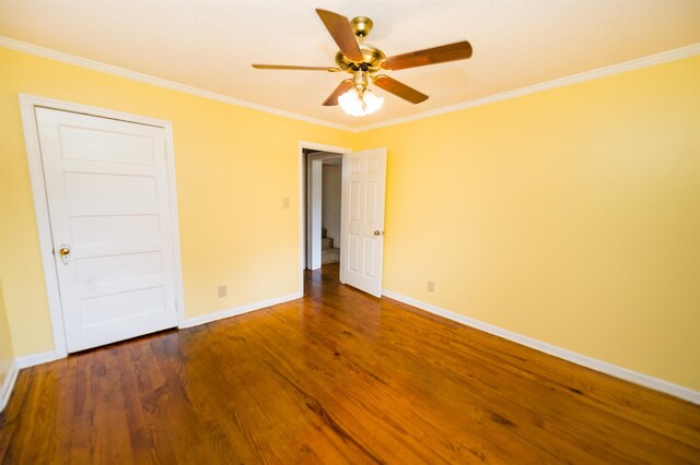 unfurnished bedroom with dark hardwood / wood-style flooring, ornamental molding, and ceiling fan