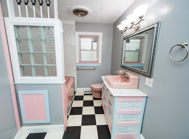 bathroom featuring tile patterned flooring, toilet, and vanity