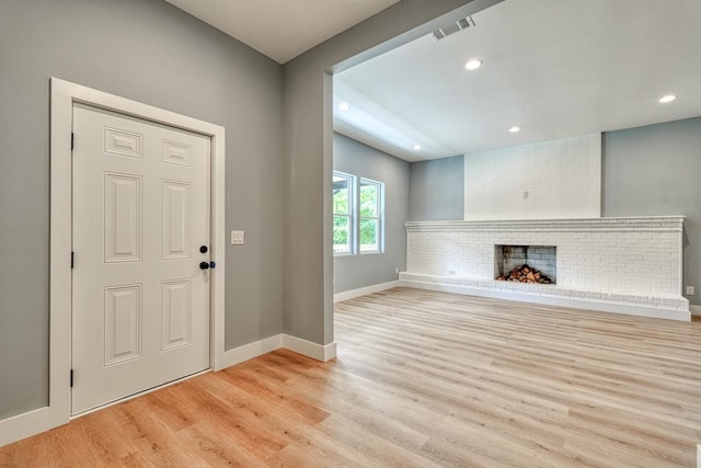 foyer with a fireplace and light hardwood / wood-style floors