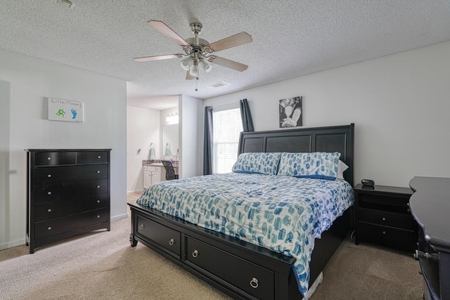 bedroom featuring light colored carpet, ensuite bathroom, a textured ceiling, and ceiling fan