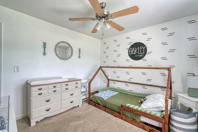 carpeted bedroom featuring a textured ceiling, ceiling fan, and multiple windows