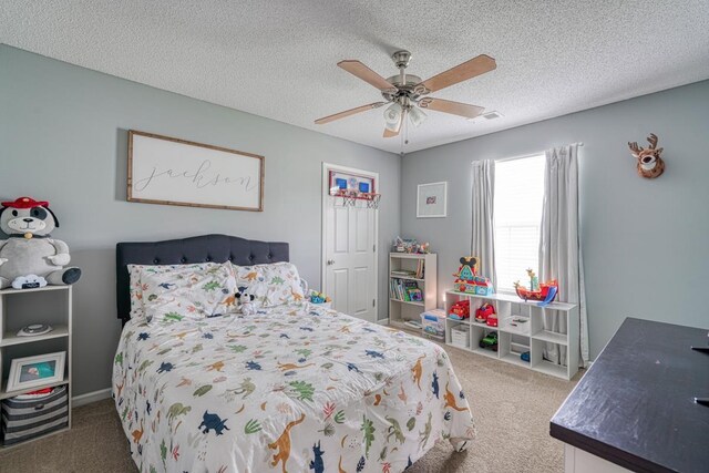 bedroom with a textured ceiling, ceiling fan, and light carpet