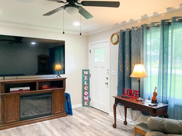 living room featuring ceiling fan, ornamental molding, and wood-type flooring