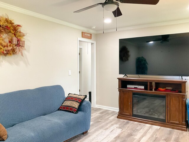 living room with ceiling fan, crown molding, and light wood-type flooring