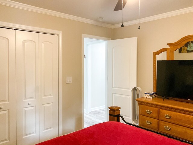 bedroom with ceiling fan, crown molding, a closet, and light wood-type flooring