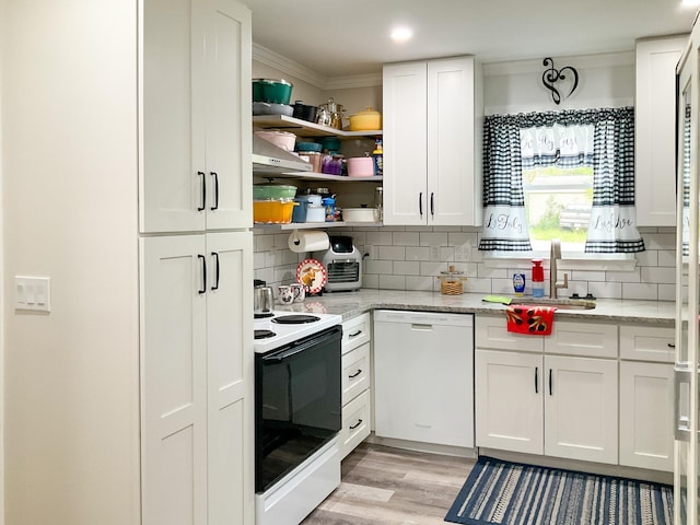 kitchen featuring a sink, white appliances, white cabinetry, and crown molding