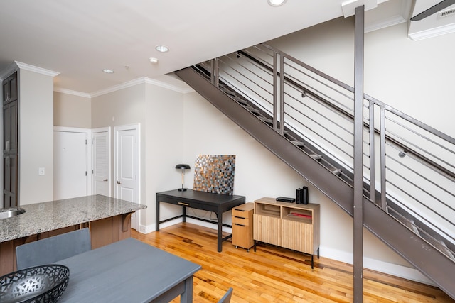 interior space featuring light wood-type flooring, crown molding, and stone counters