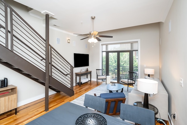 living room with ceiling fan, french doors, crown molding, and light wood-type flooring