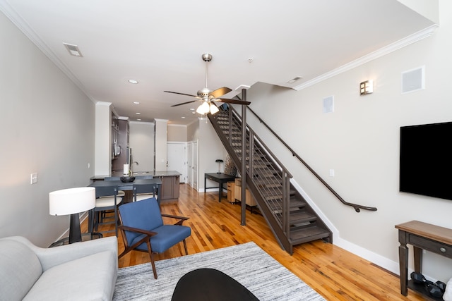 living room with ceiling fan, light hardwood / wood-style floors, and ornamental molding