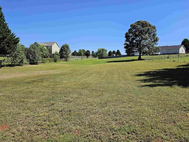 view of yard featuring fence and a rural view