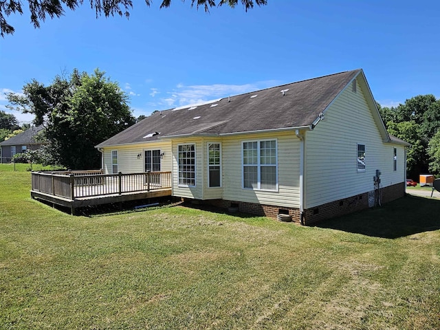 rear view of property featuring crawl space, a wooden deck, and a yard