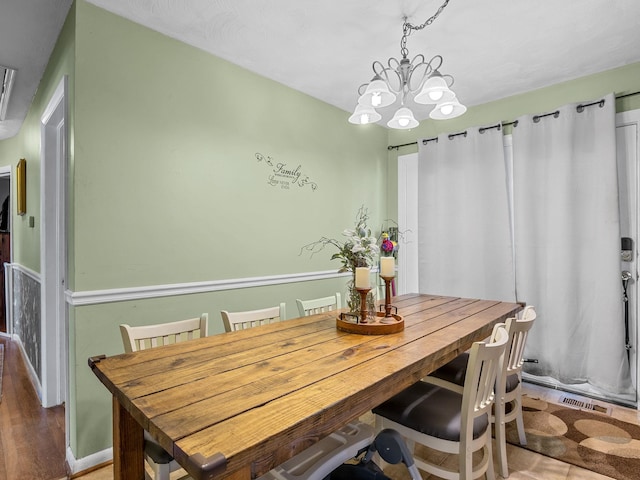 dining area featuring a chandelier and wood-type flooring