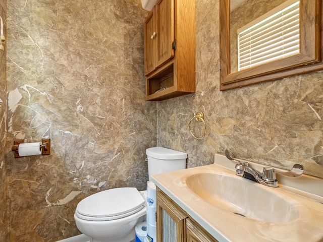 bathroom featuring tile walls, vanity, and toilet