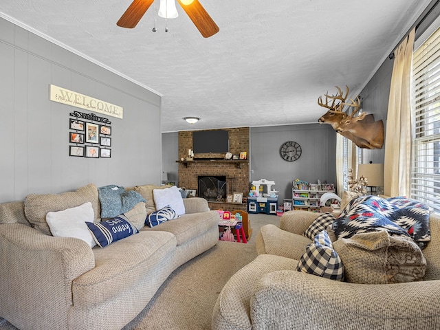 living room with brick wall, crown molding, a fireplace, a textured ceiling, and ceiling fan