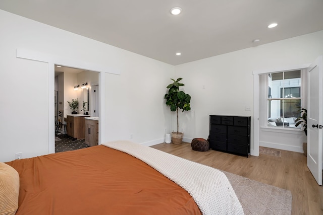 bedroom with ensuite bath, baseboards, wood finished floors, and recessed lighting