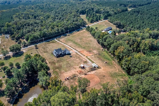 aerial view featuring a wooded view and a rural view