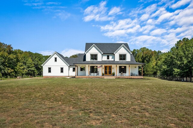 modern farmhouse style home with roof with shingles, a porch, board and batten siding, and a front lawn