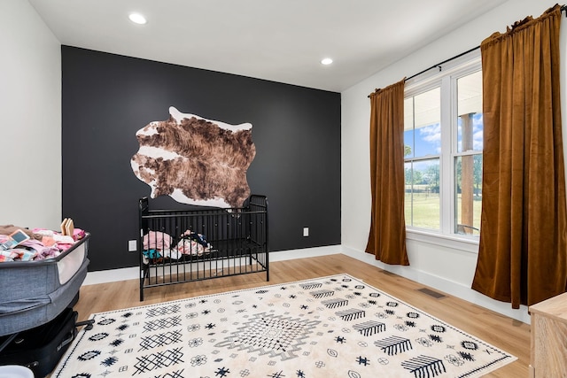 bedroom featuring baseboards, visible vents, wood finished floors, and recessed lighting