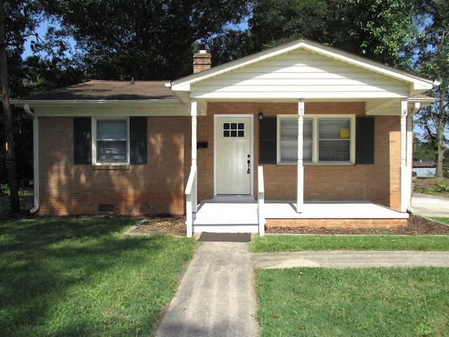 bungalow-style house featuring covered porch and a front yard