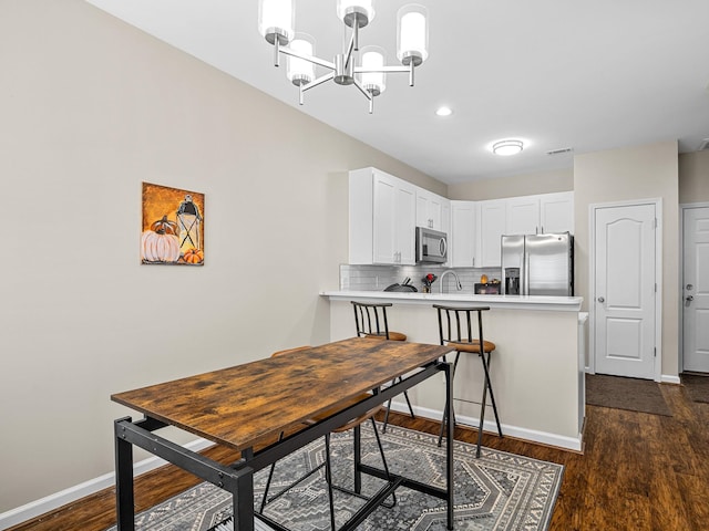 dining area featuring a chandelier and dark hardwood / wood-style floors