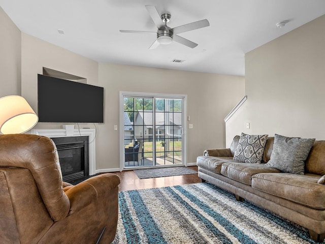 living room featuring wood-type flooring and ceiling fan