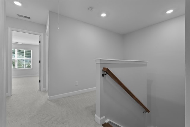 hallway with attic access, visible vents, an upstairs landing, carpet floors, and recessed lighting