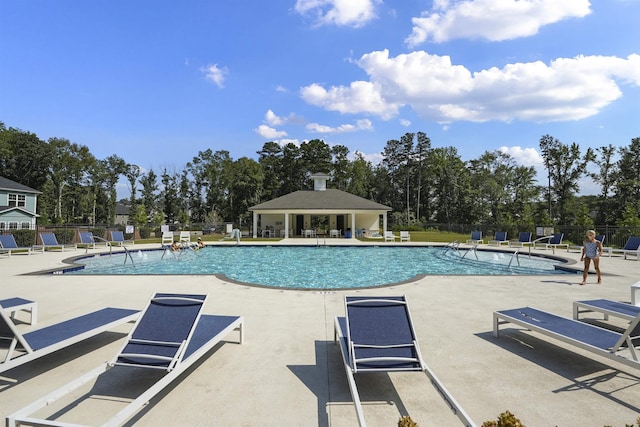 community pool with a patio and fence