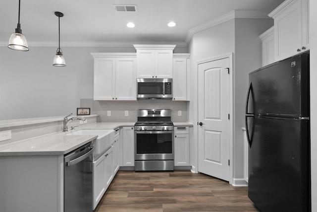 kitchen featuring stainless steel appliances, light countertops, a sink, and crown molding