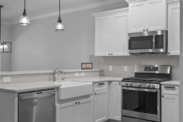 kitchen featuring stainless steel appliances, a peninsula, a sink, ornamental molding, and decorative backsplash