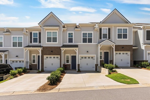 multi unit property featuring a garage, driveway, and brick siding