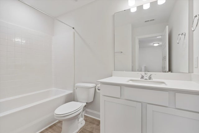 bathroom featuring visible vents, toilet, wood finished floors,  shower combination, and vanity