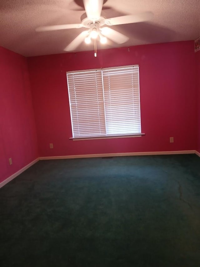 carpeted empty room featuring ceiling fan and a textured ceiling