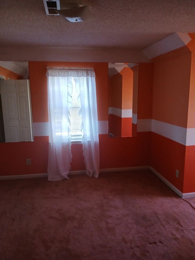 spare room featuring carpet and a textured ceiling