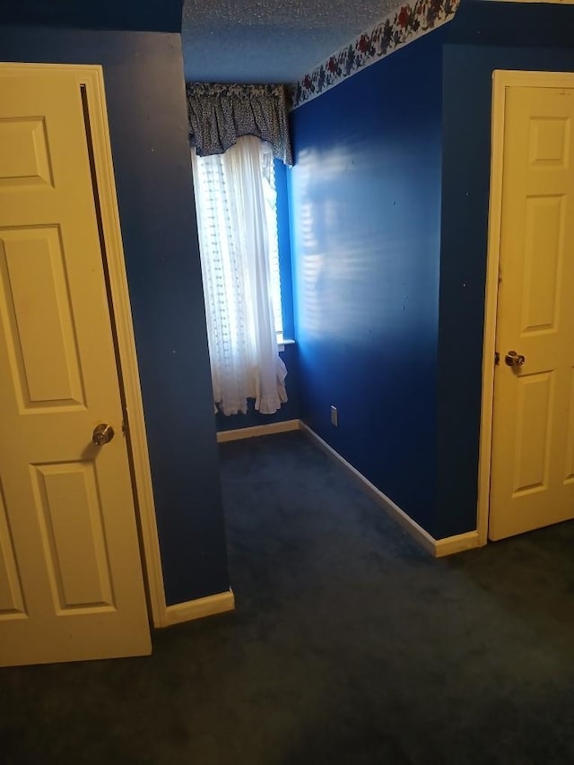 carpeted spare room featuring a textured ceiling