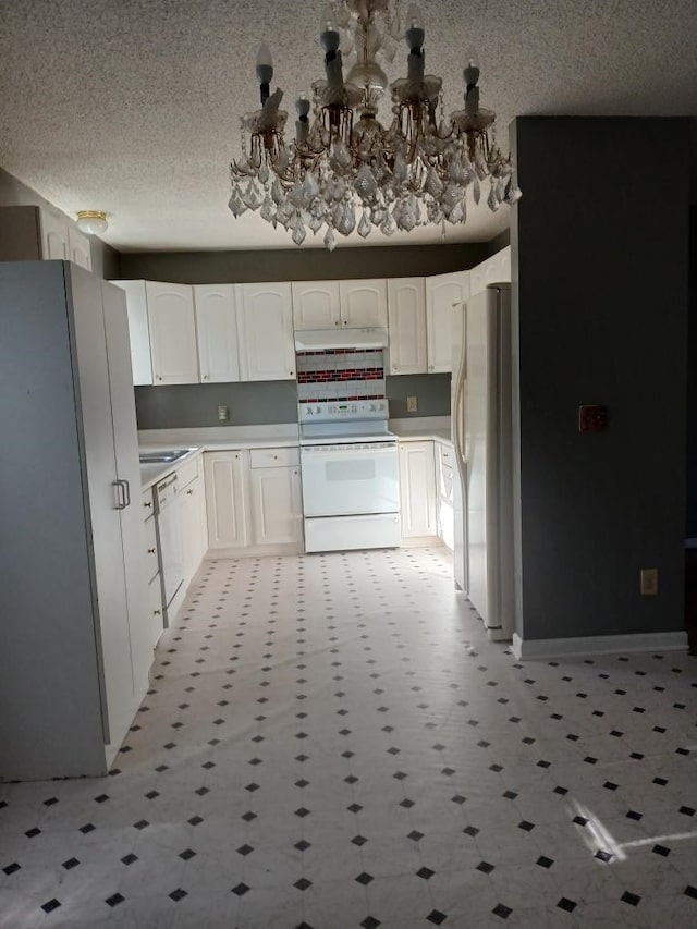 kitchen featuring a textured ceiling, white cabinets, a chandelier, and white appliances