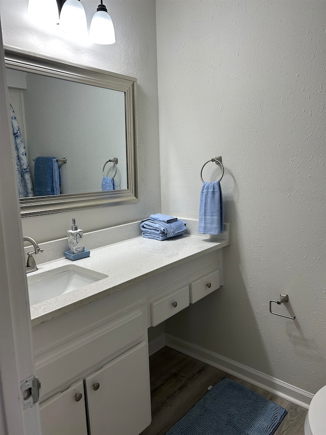 bathroom featuring vanity, toilet, and hardwood / wood-style flooring