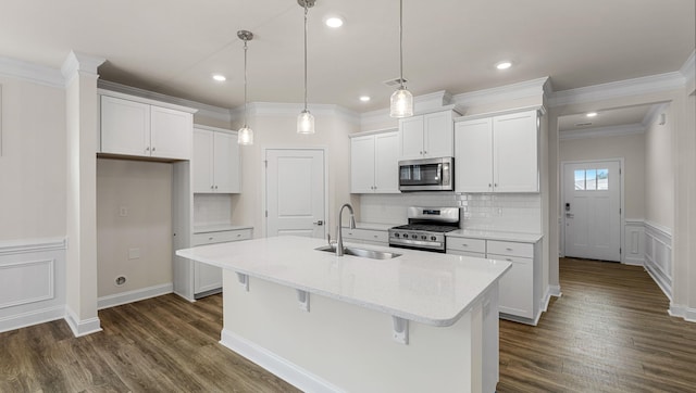 kitchen featuring stainless steel appliances, a kitchen island with sink, sink, and white cabinets