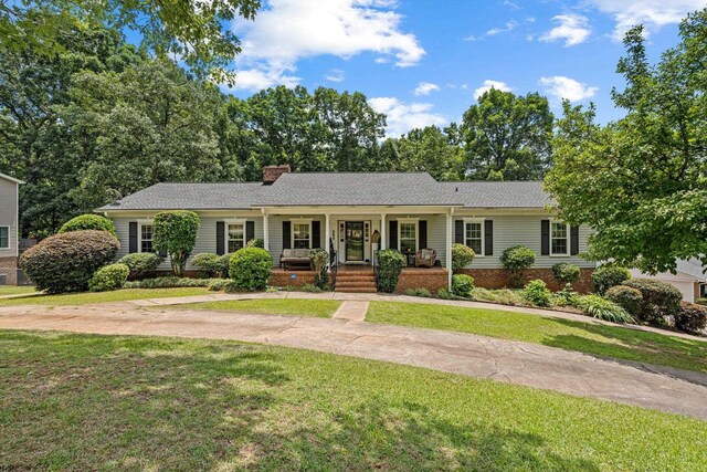 single story home featuring a front lawn and covered porch