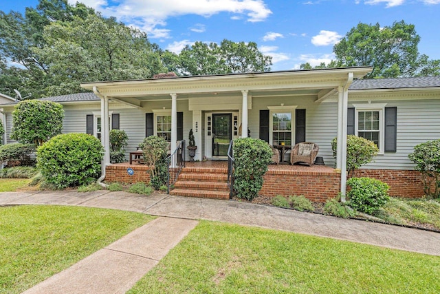 view of front facade with covered porch and a front yard