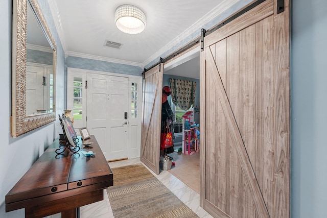 entrance foyer with ornamental molding and a barn door